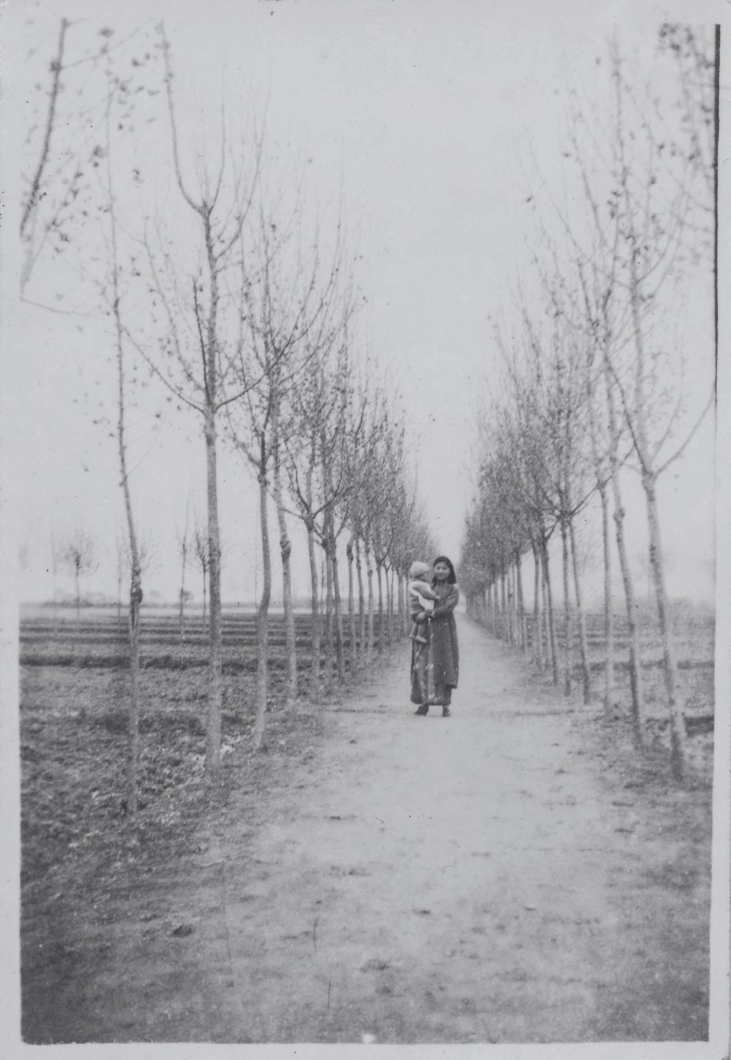"Chinese mother holds her baby on a tree-lined path (14042256450)" by simpleinsomnia is licensed under CC BY 2.0.